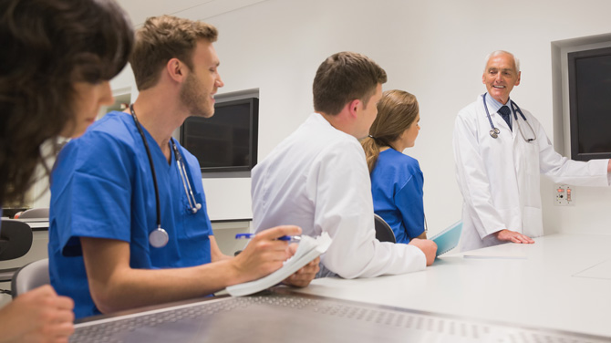 Older male doctor presenting to medical students