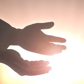 Hands outstretched in front of the sun
